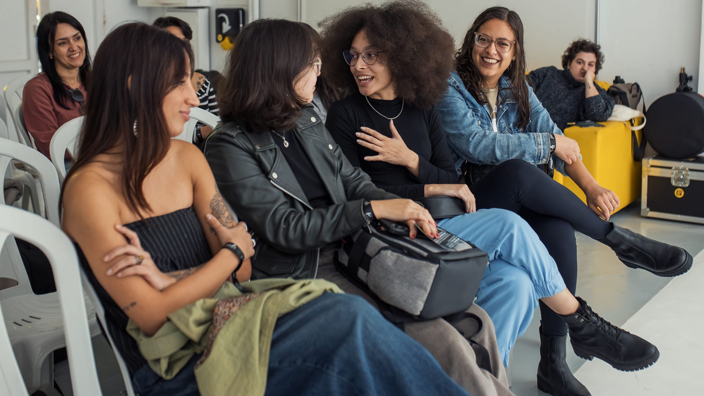 People seated in a loose circle mid-conversation at an informal session.